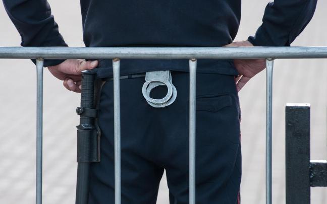 Un policía ruso con unas esposas y una porra.