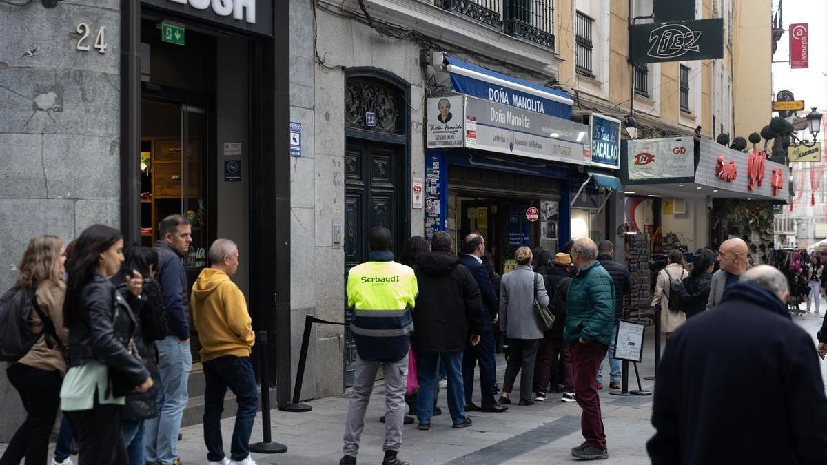 Varias personas hacen cola para comprar la Lotería de Navidad