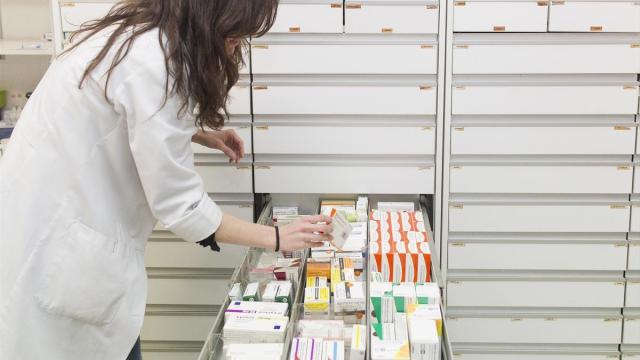 Una farmacéutica busca un medicamento.