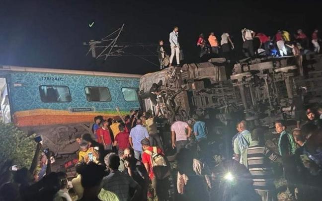 Un grupo de personas intenta rescatar a los pasajeros atrapados.