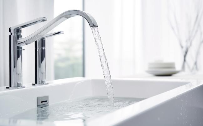 Un potente chorro de agua cae del grifo de un lavabo.