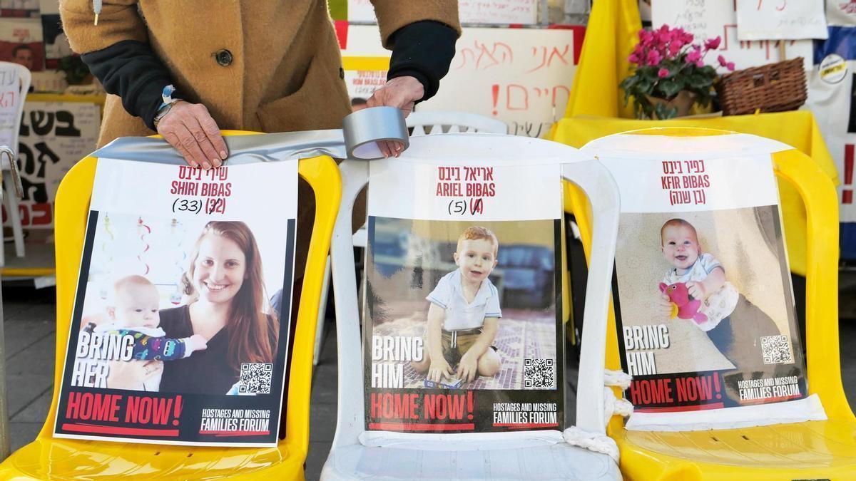 Una mujer coloca un cartel con la imagen de Shiri Bibas en una silla vacía durante una protesta en Jerusalén.