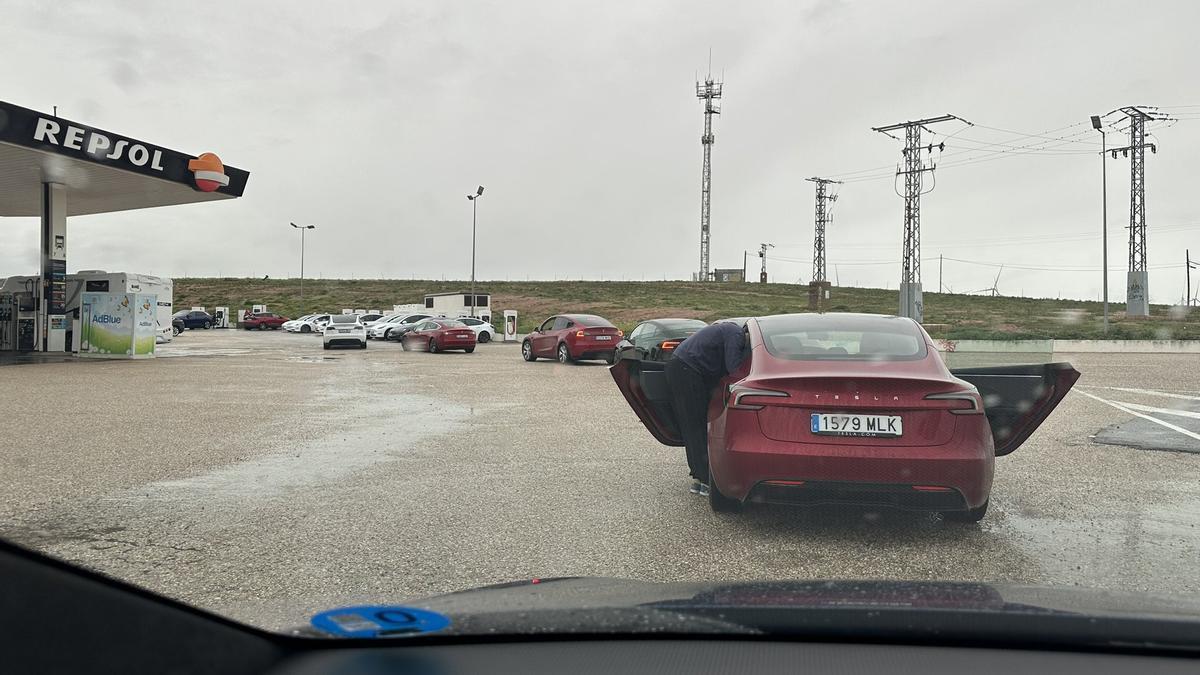 Una fila de coches Tesla, esperando al cargador.