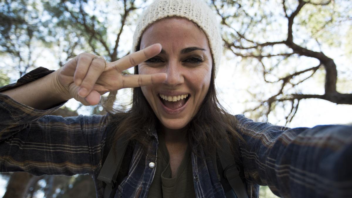 Una joven se hace un selfie con los dedos en V.
