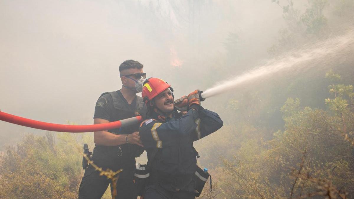 Imagen de archivo de dos bomberos trabajando en la extinción de un incendio en Vati, en la isla griega de Rodas.