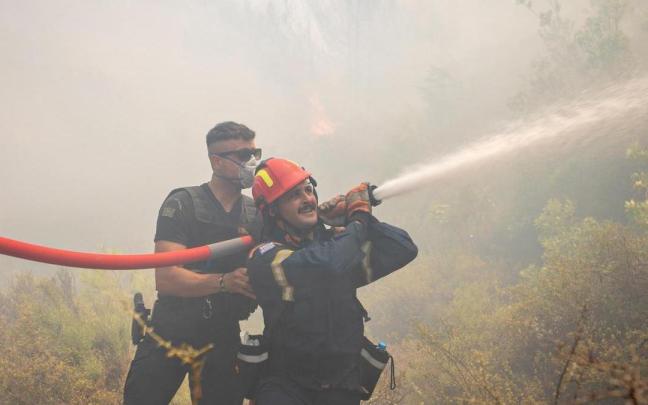 Imagen de archivo de dos bomberos trabajando en la extinción de un incendio en Vati, en la isla griega de Rodas.