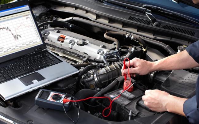 Un mecánico comprueba el estado de un coche.