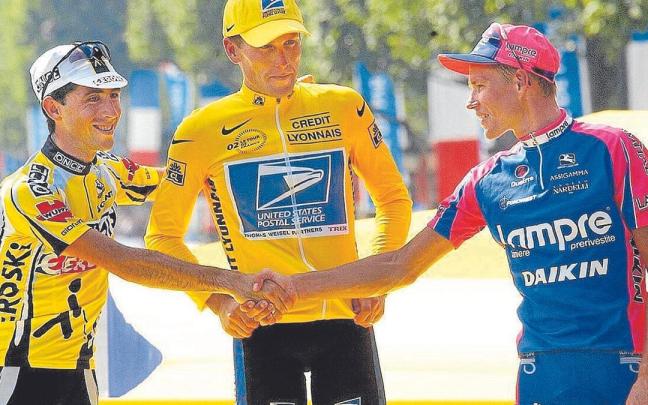 Beloki, segundo en el Tour de 2002, estrecha la mano a Rumsas ante la mirada de Armstrong