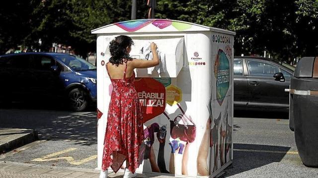 Una mujer deposita una prenda de ropa en uno de los contenedores de Koopera