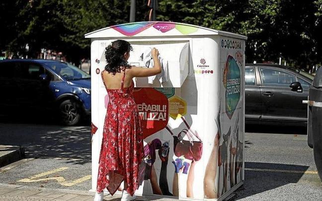 Una mujer deposita una prenda de ropa en uno de los contenedores de Koopera