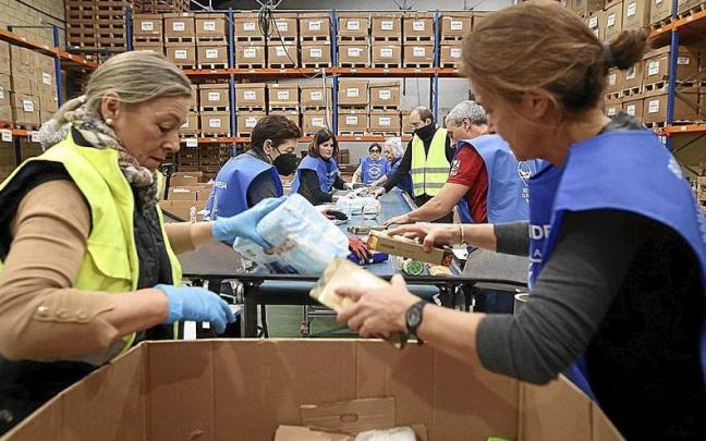 Voluntarios trabajan en un banco de alimentos.