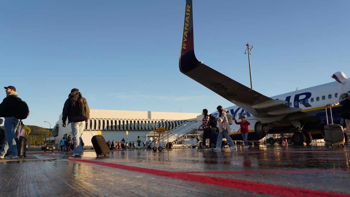 Pasajeros junto a un avión en el aeropuerto de Castellón.