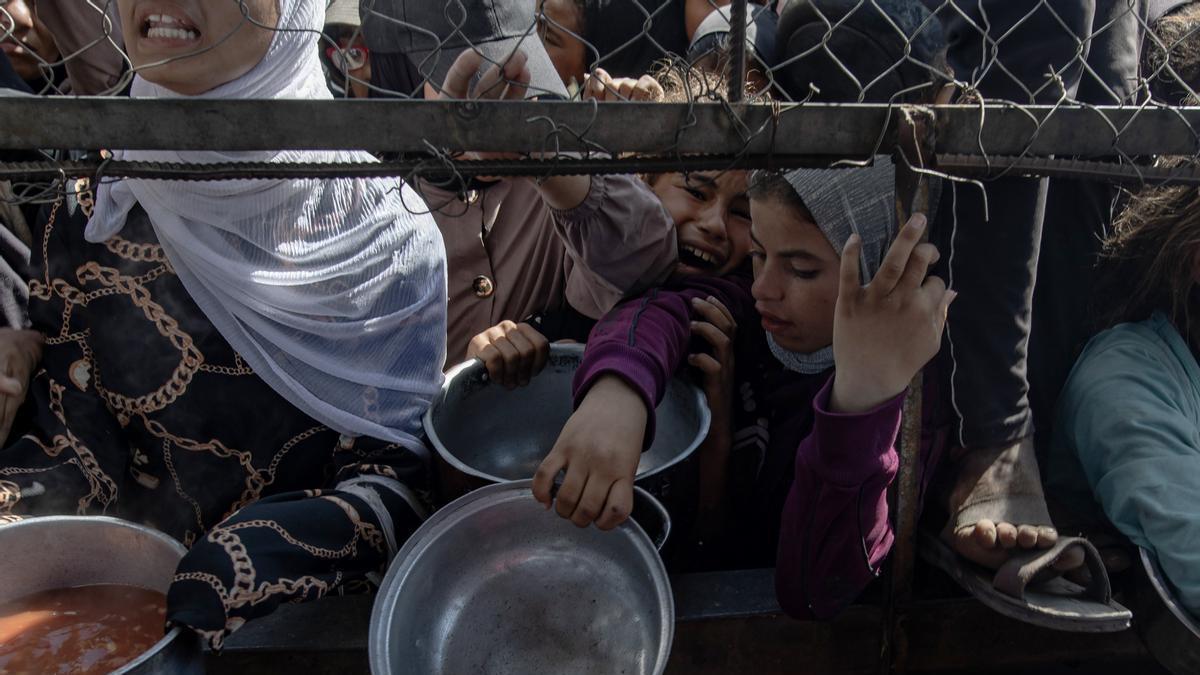 Refugiados palestinos recogen alimentos en la Franja de Gaza.