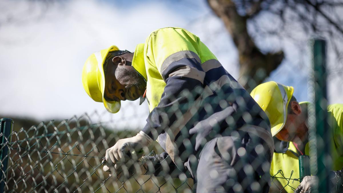 Un trabajador senegalés arregla una valla.