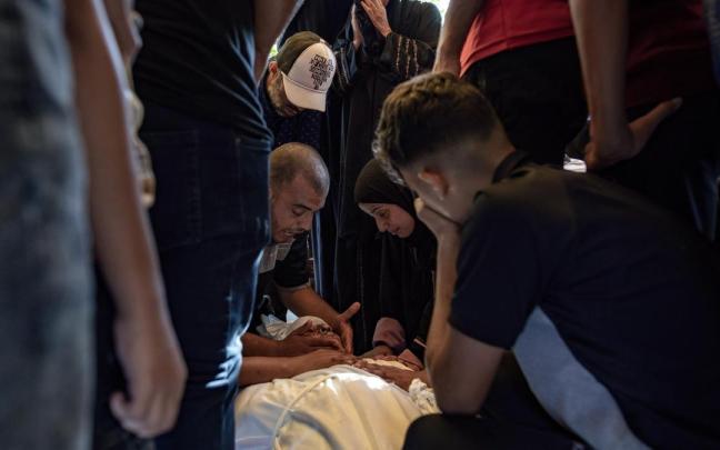 Un grupo de palestinos atiende a un herido en un bombardeo en Jan Yunis, en la Franja de Gaza