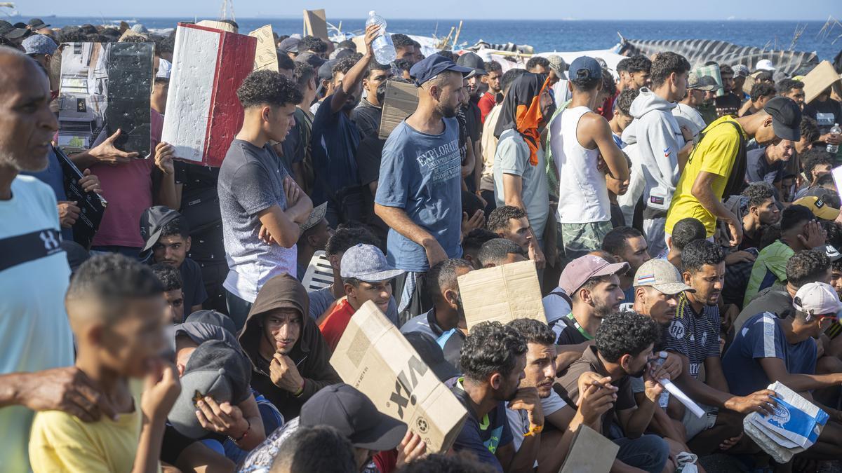 Varios migrantes en la playa de Trampolín.