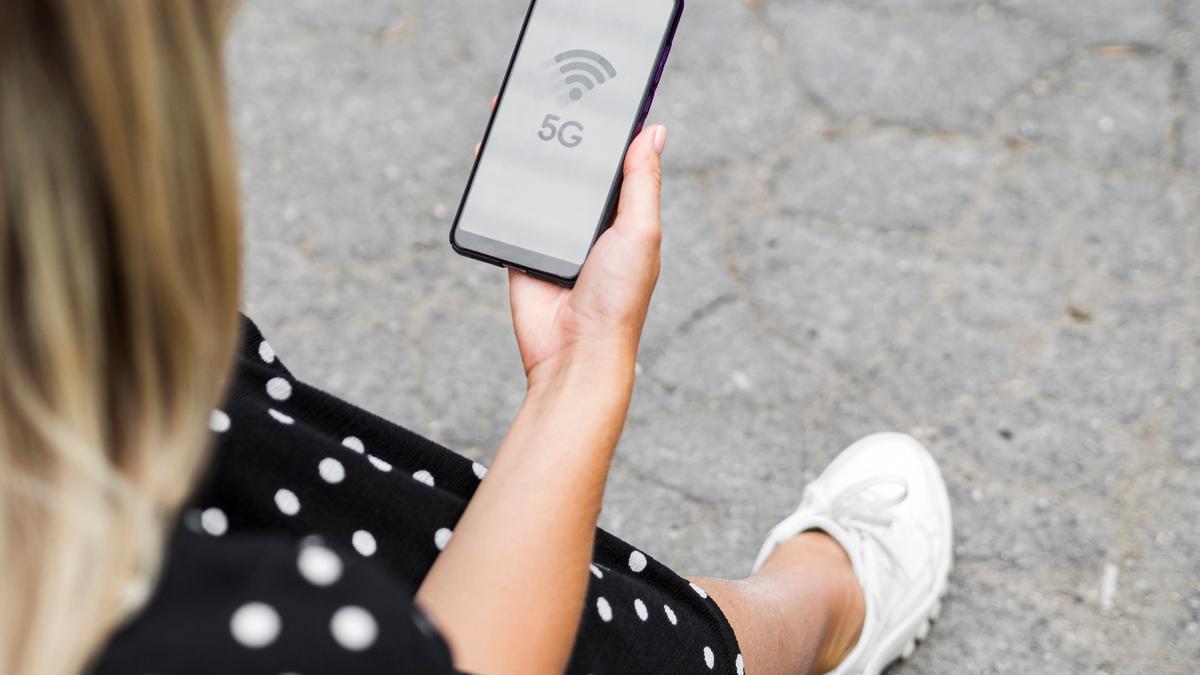 Una mujer busca la señal wifi para conectarse.