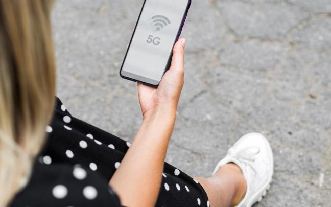 Una mujer busca la señal wifi para conectarse.