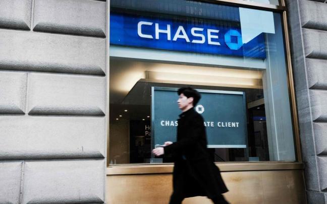 Un hombre pasea ante una oficina de JPMorgan Chase en Nueva York.