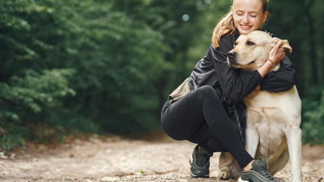 Una mujer abraza a su perro.