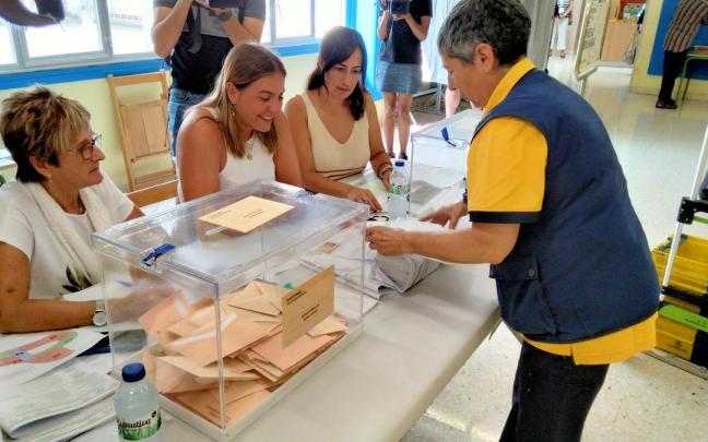 Una trabajadora de Correos depositando los votos por correo en una mesa electoral. Una trabajadora de Correos depositando los votos por correo en una mesa electoral.