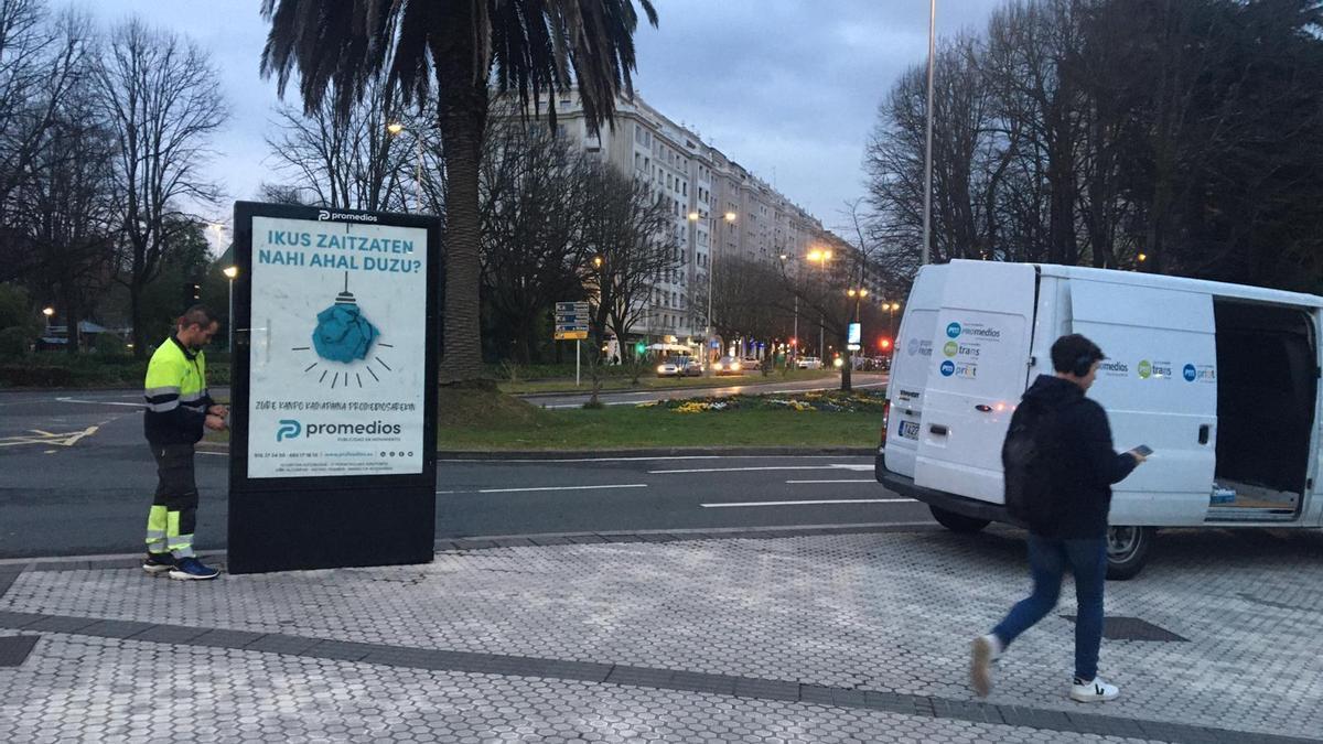 Imagen del operario que ya ha quitado el cartel que hacía referencia a la Conferencia Episcopal.