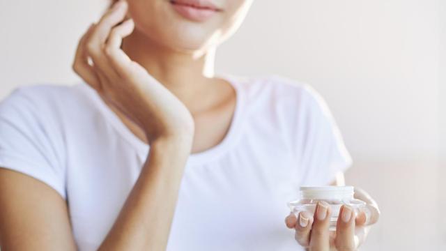 Chica aplica crema en el rostro en su rutina de cuidado facial.