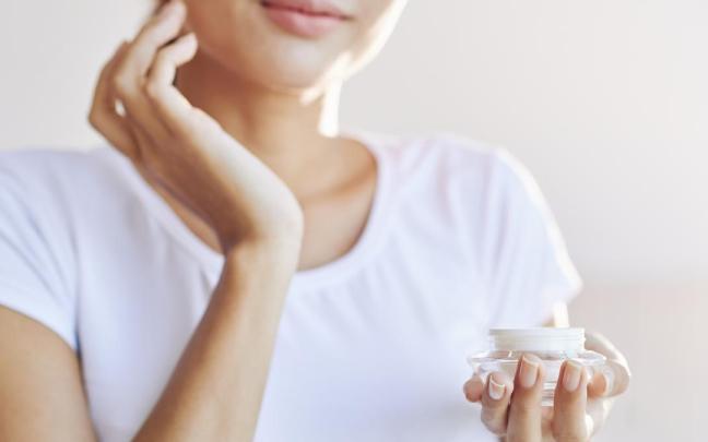 Chica aplica crema en el rostro en su rutina de cuidado facial.