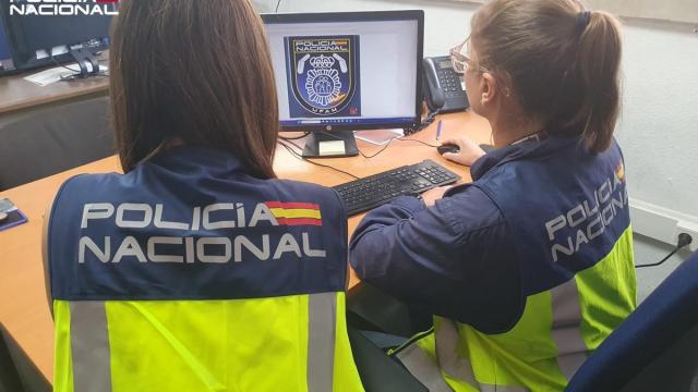 Dos agentes de la Policía Nacional, de espaldas.