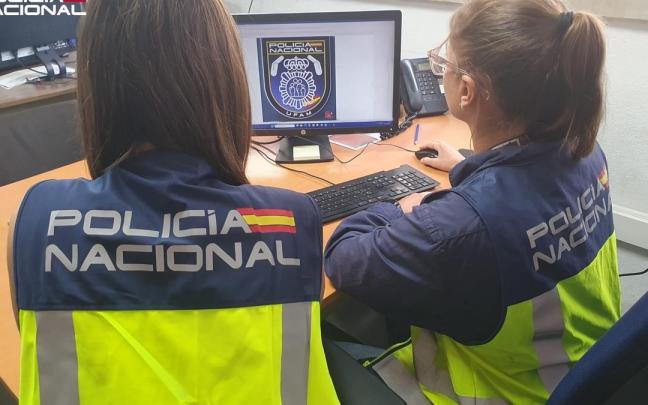 Dos agentes de la Policía Nacional, de espaldas.