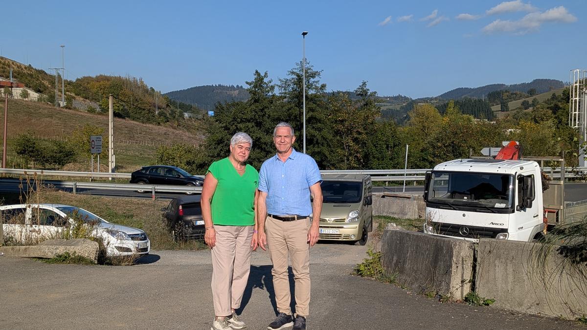 El portavoz del PNV, Josu Ezkurdia, y la edil Maite Uribe, en el lugar donde proponen crear el aparcamiento para vehículos compartidos, en Intxaurtxueta, aprovechando el espacio entre los estacionamientos actuales y la carretera de acceso a la autopi