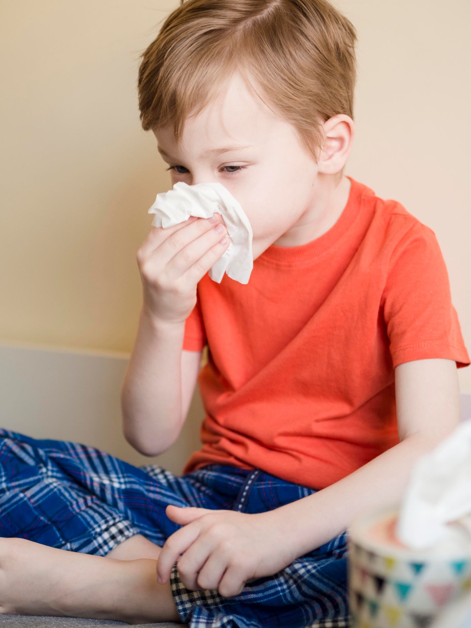 Un niño, con síntomas de alergia, se suena la nariz.