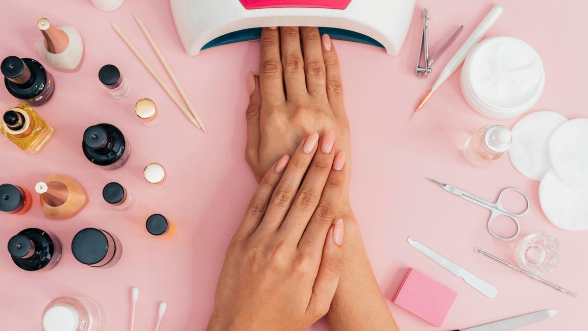 Aparato para secar las uñas junto a otros útiles de manicura.