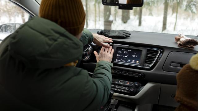 Un hombre se calienta dentro de su coche.