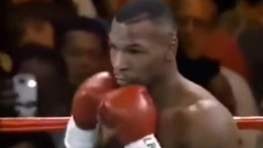 Tyson, en plena pelea, con el aficionado con el supuesto 'smartphone' detrás.