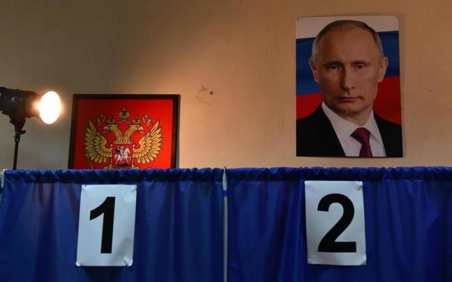 Imagen de Vladimir Putin en un colegio electoral