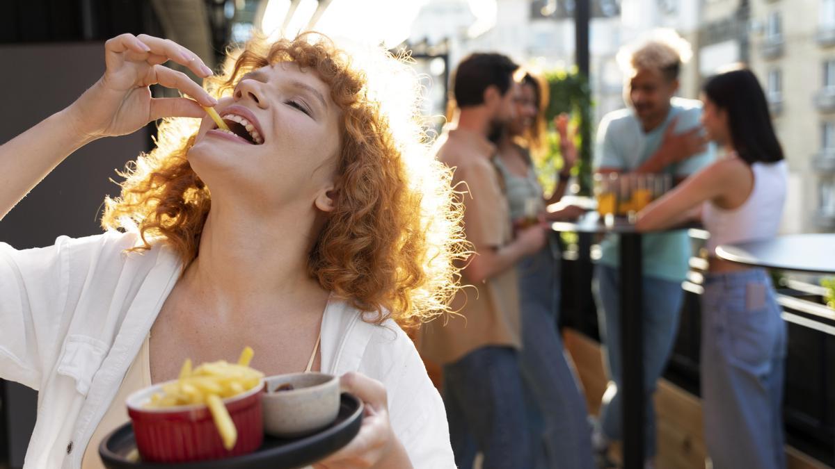 Una chica comiendo patatas fritas.