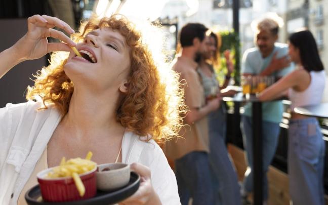 Una chica comiendo patatas fritas.