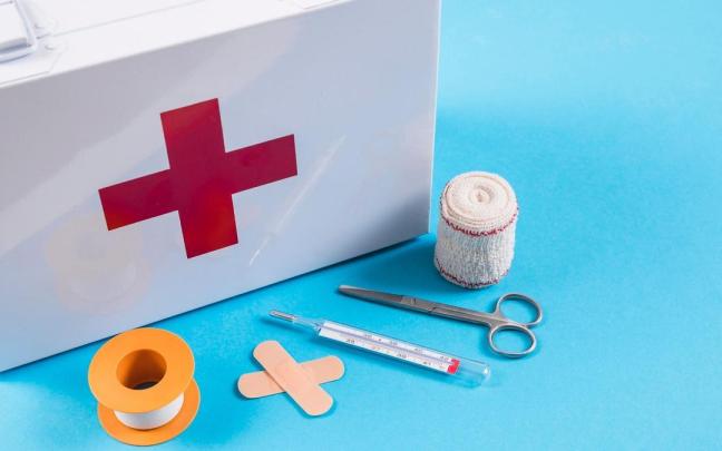Una caja de botiquín con algunos elementos del kit de primeros auxilios.