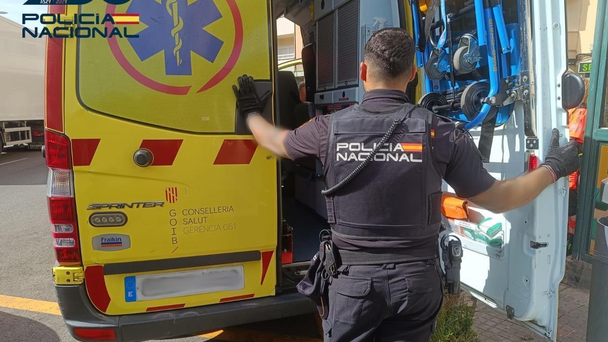 Un policía junto a una ambulancia