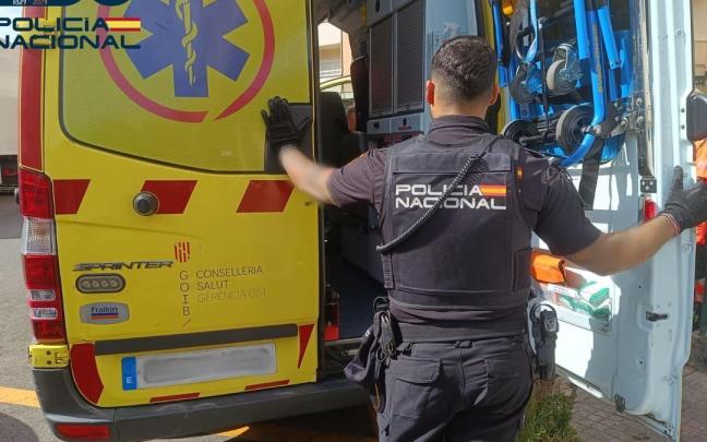 Un policía junto a una ambulancia