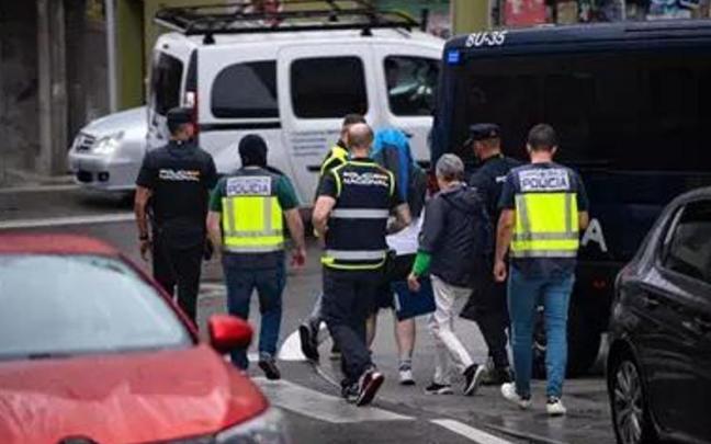 Agentes de policía trasladan a un detenido durante un operativo policial en Rúa do Progreso, a 1 de agosto de 2023, en Sanxenxo