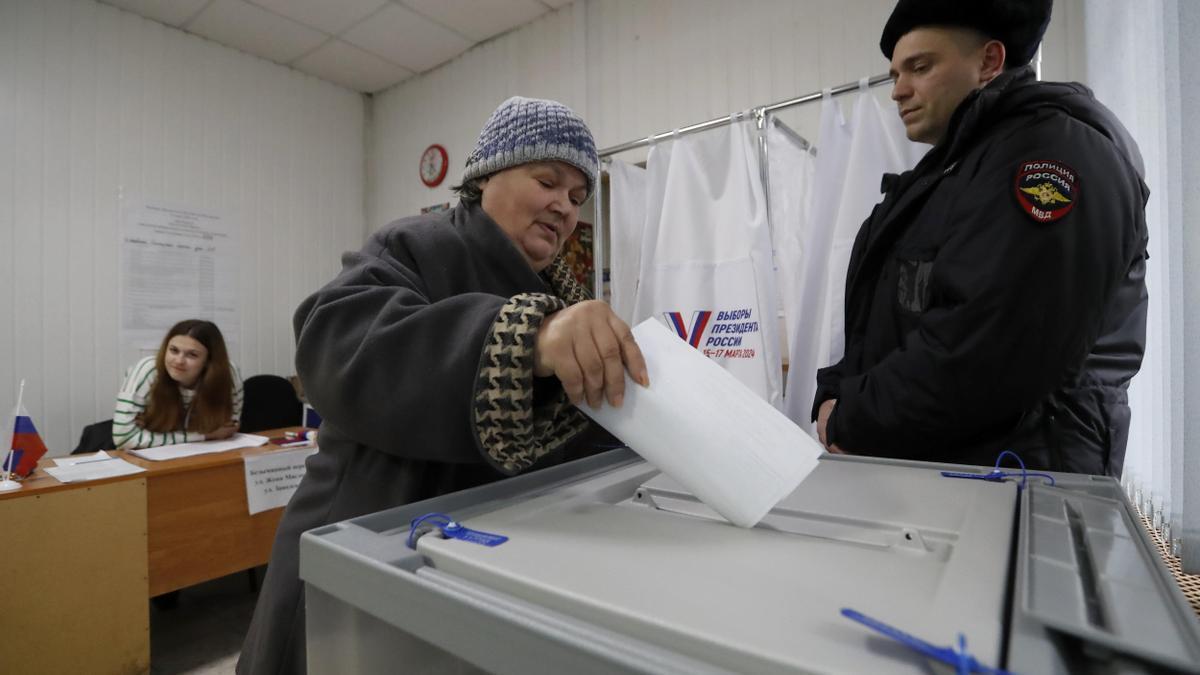 Una mujer deposita su voto en un centro electoral en San Petersburgo.