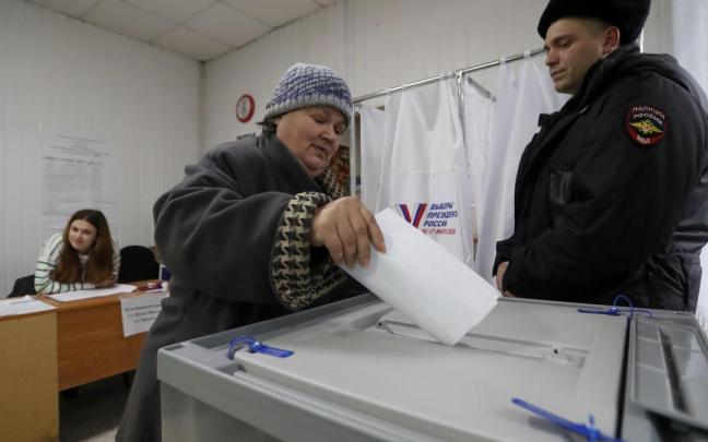 Una mujer deposita su voto en un centro electoral en San Petersburgo.