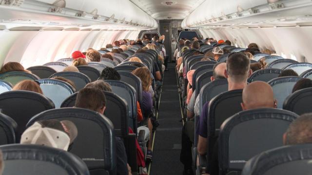 Los pasajeros de un avión ocupan sus asientos.