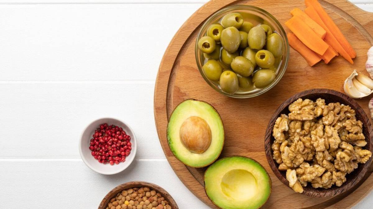 Diferentes alimentos saludables que se pueden tomar como snack sobre una tabla de madera.