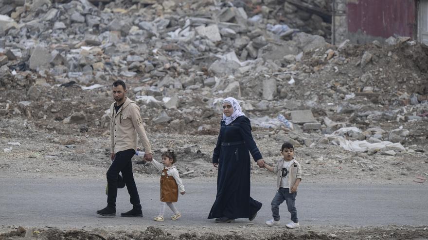 Una familia camina entre los escombros de una zona residencial de Kahramanmaras, Turquía.