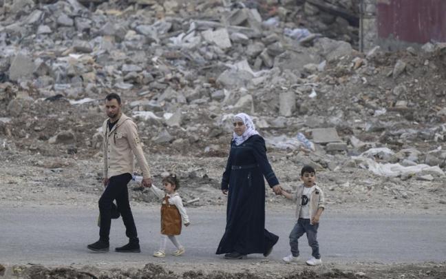 Una familia camina entre los escombros de una zona residencial de Kahramanmaras, Turquía.