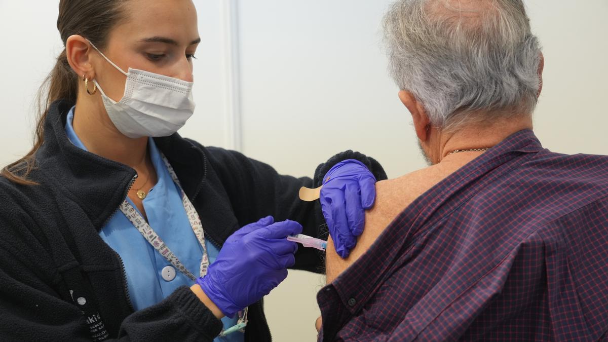 Una persona se vacuna, en un centro de refuerzo de vacunación frente a la gripe