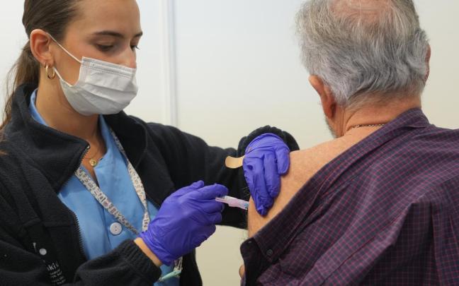 Una persona se vacuna, en un centro de refuerzo de vacunación frente a la gripe